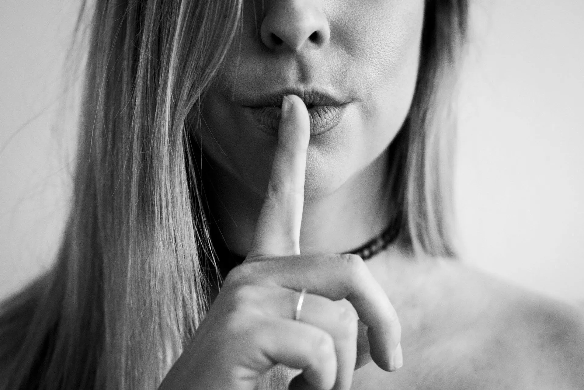 Nuori naissisällöntuottaja istuu pöydän ääressä kirjoittaen muistiinpanoja sisällön sääntöjen noudattamisesta.